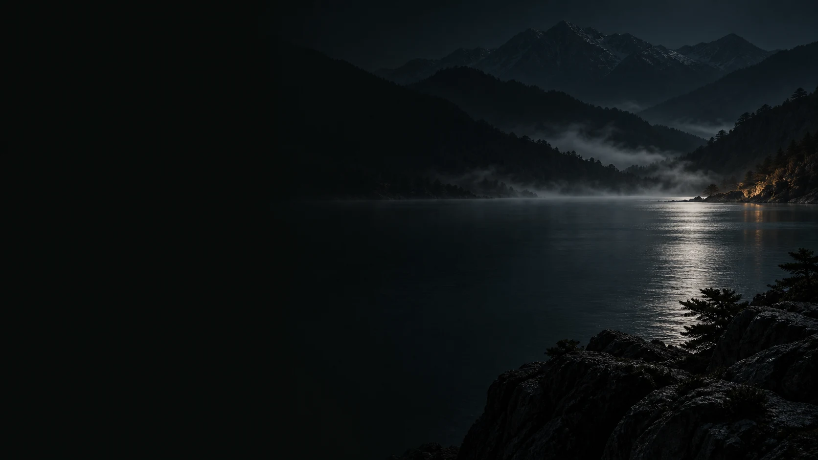 Dark mountain silhouettes and a still lake at midnight